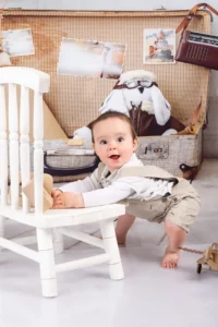 Portrait d'un petit garçon penché sur un chaise dans un décor sur le thème voyage, par Ael Photos en studio dans le Finistère