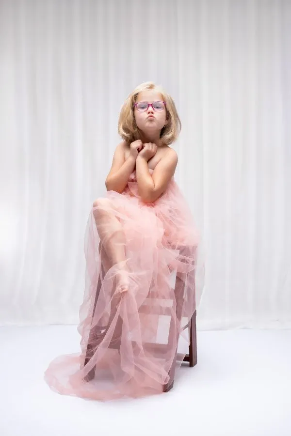Portrait studio d'une fillette drapée dans du tulle rose et qui fait la grimace, par Ael Photos à Pont de Buis dans le Finistère