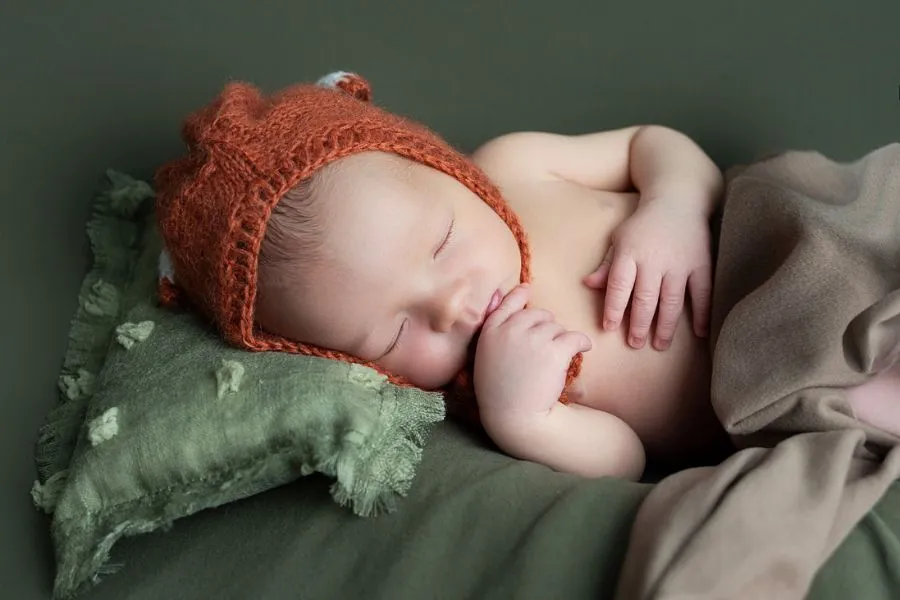 Portrait de nouveau-né avec bonnet tricot orange en studio au Faou par AEL Photos