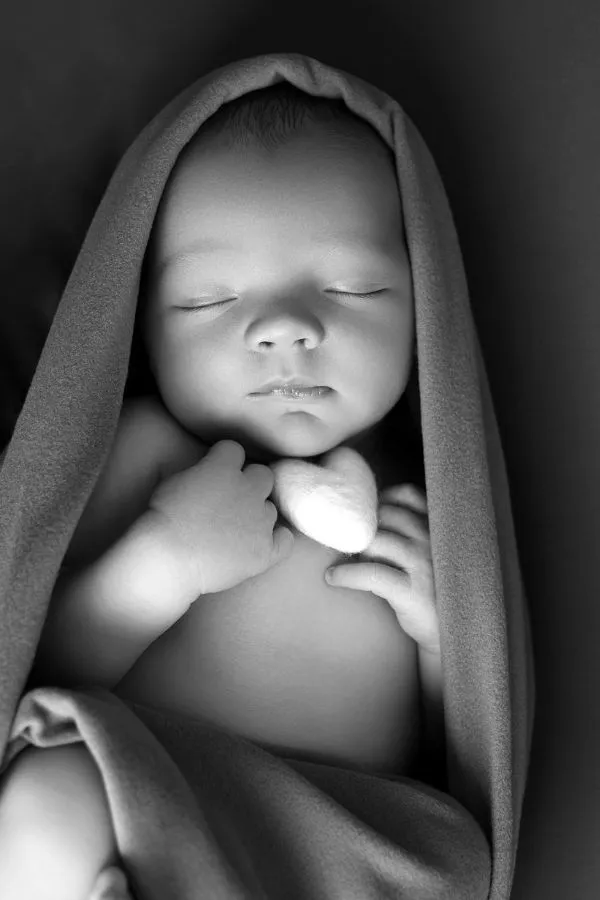 Portrait noir et blanc d’un nouveau-né endormi en studio chez AEL Photos au Faou en Bretagne