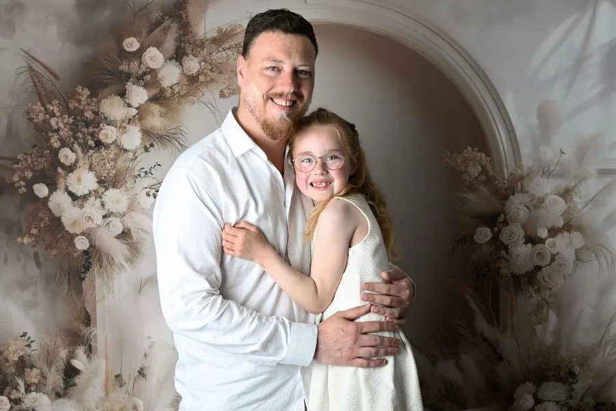 Portrait de famille d'un père qui tient sa fillette dans ses bras, au studio AEL Photos au Faou