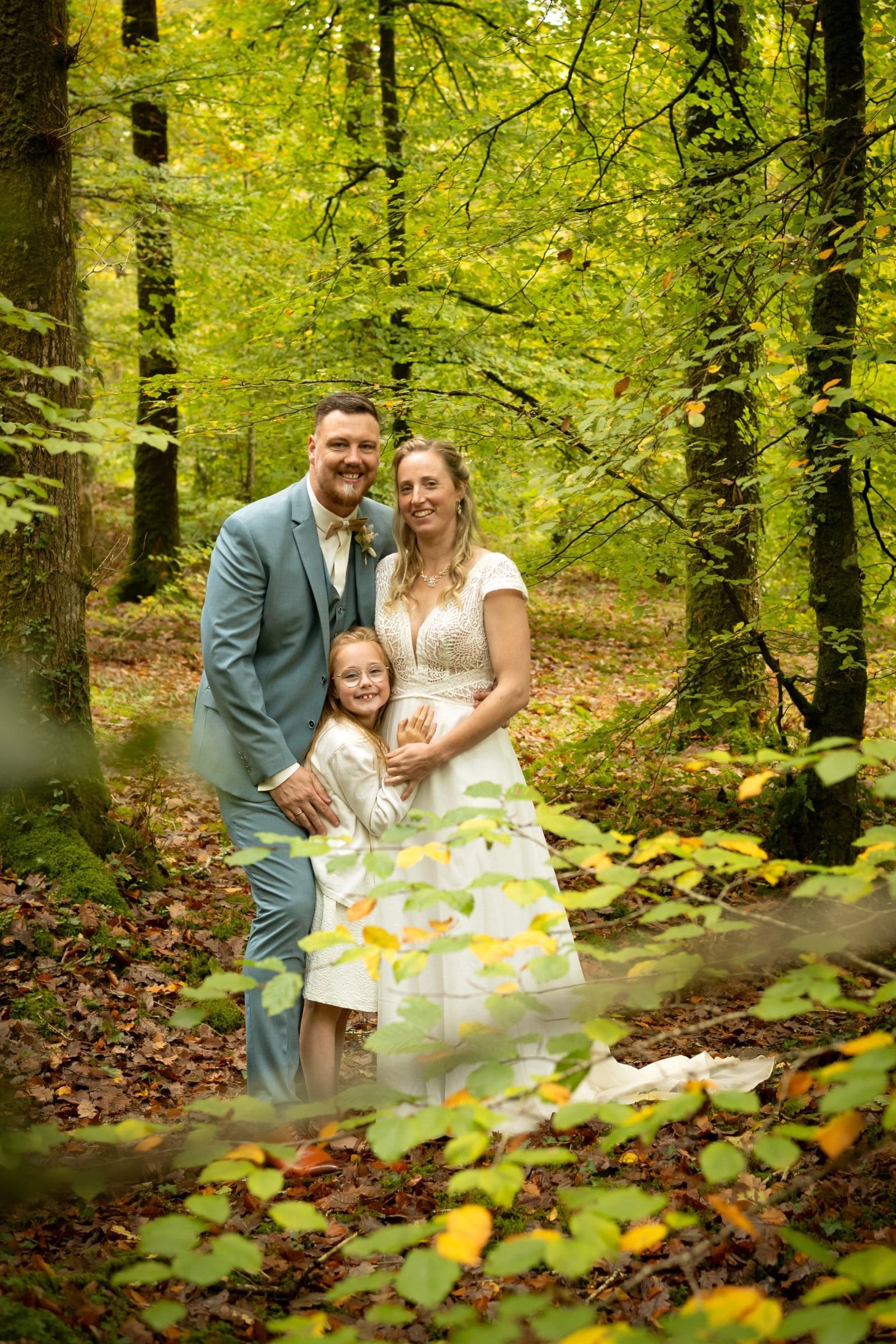 Portrait de mariage du couple des mariés accompagné de leur fille en forêt par AEL Photos, Bretagne