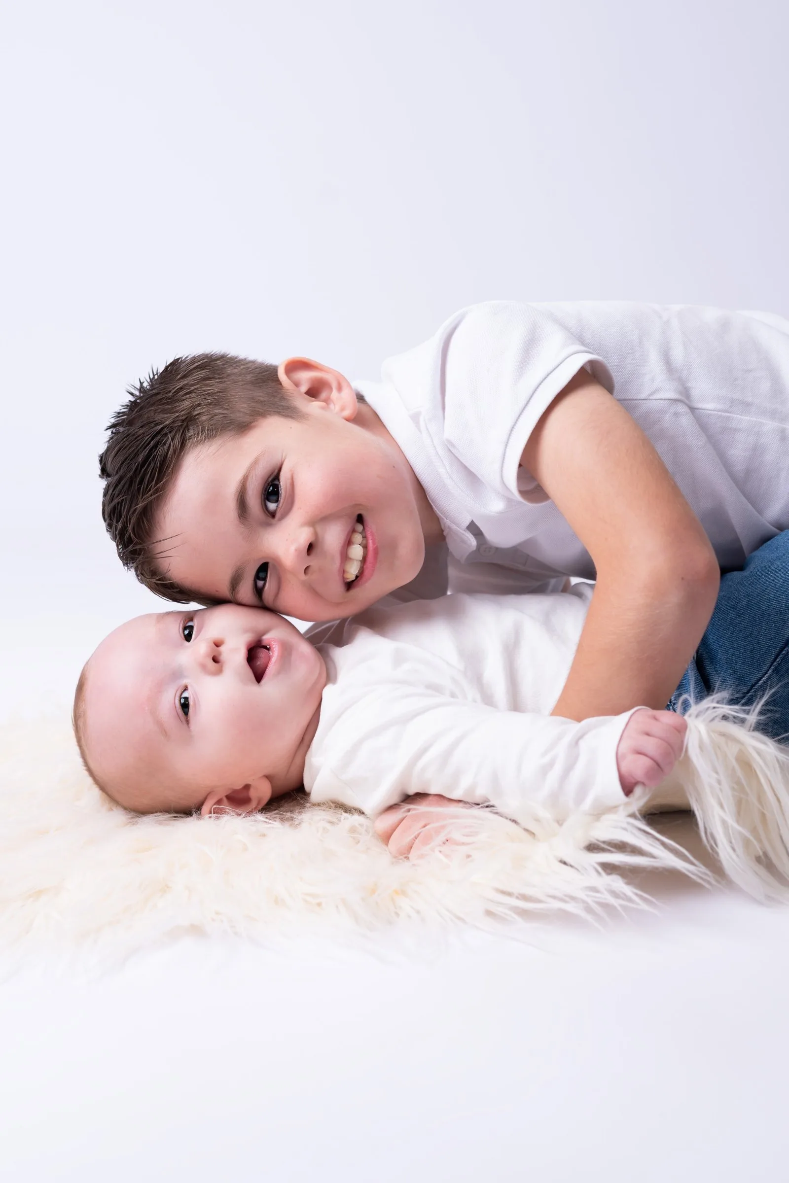 Portrait de fratrie en studio, grand frère allongé près de son petit frère
