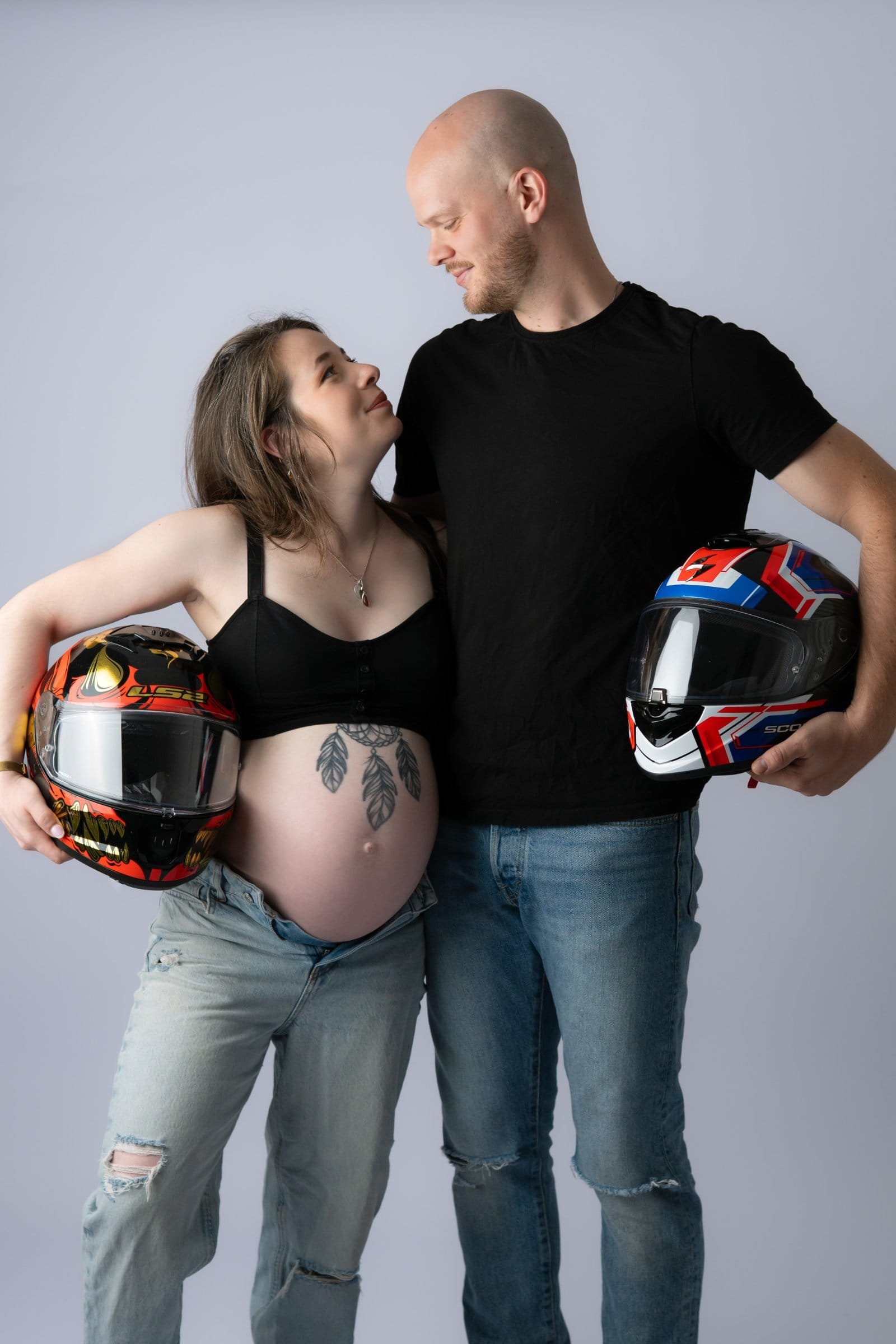 Portrait original de grossesse, couple avec casques de moto, réalisée en studio au Faou, près de Quimper.
