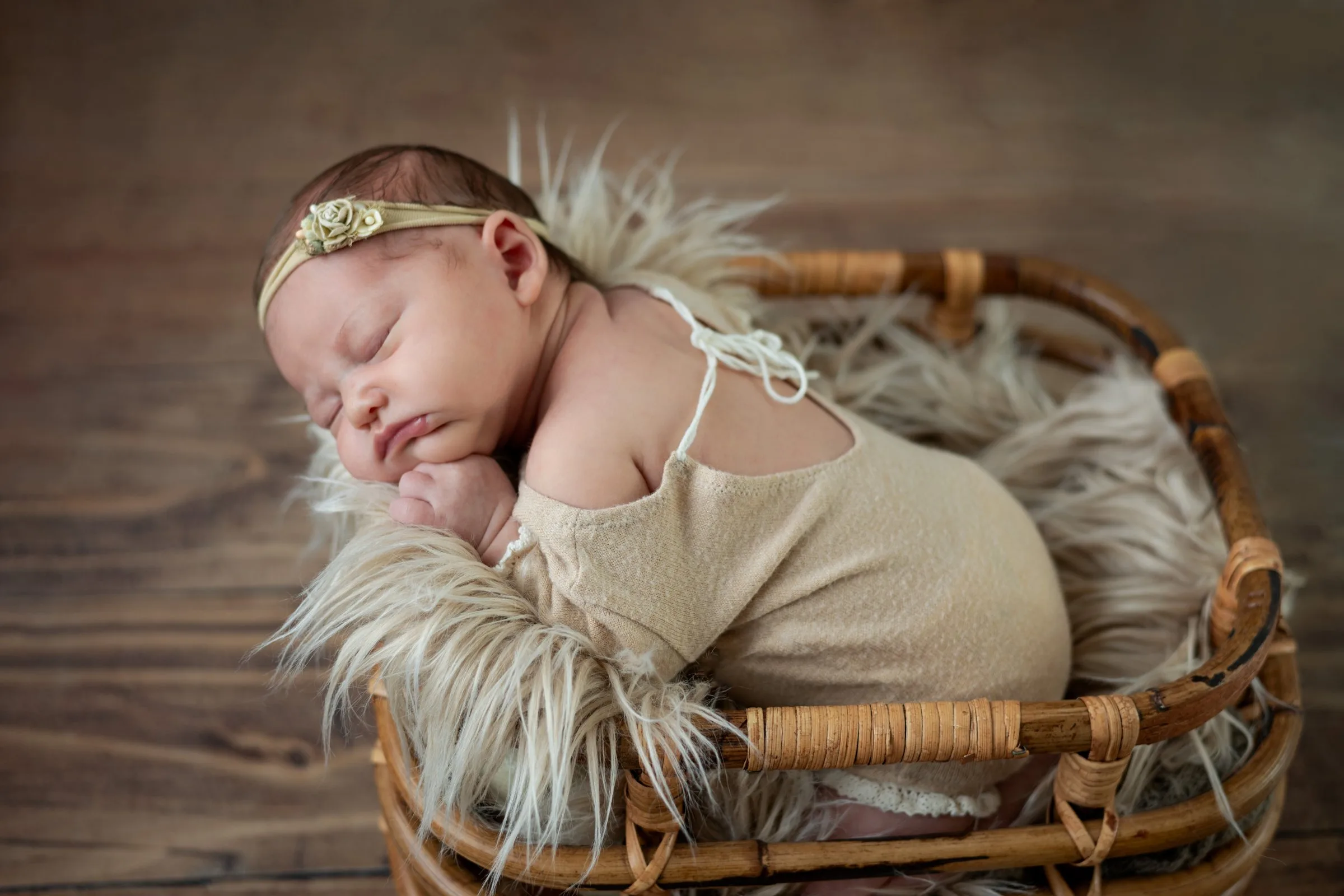 Bébé nouveau-né endormi dans un panier en bois lors d’une séance photo au Faou