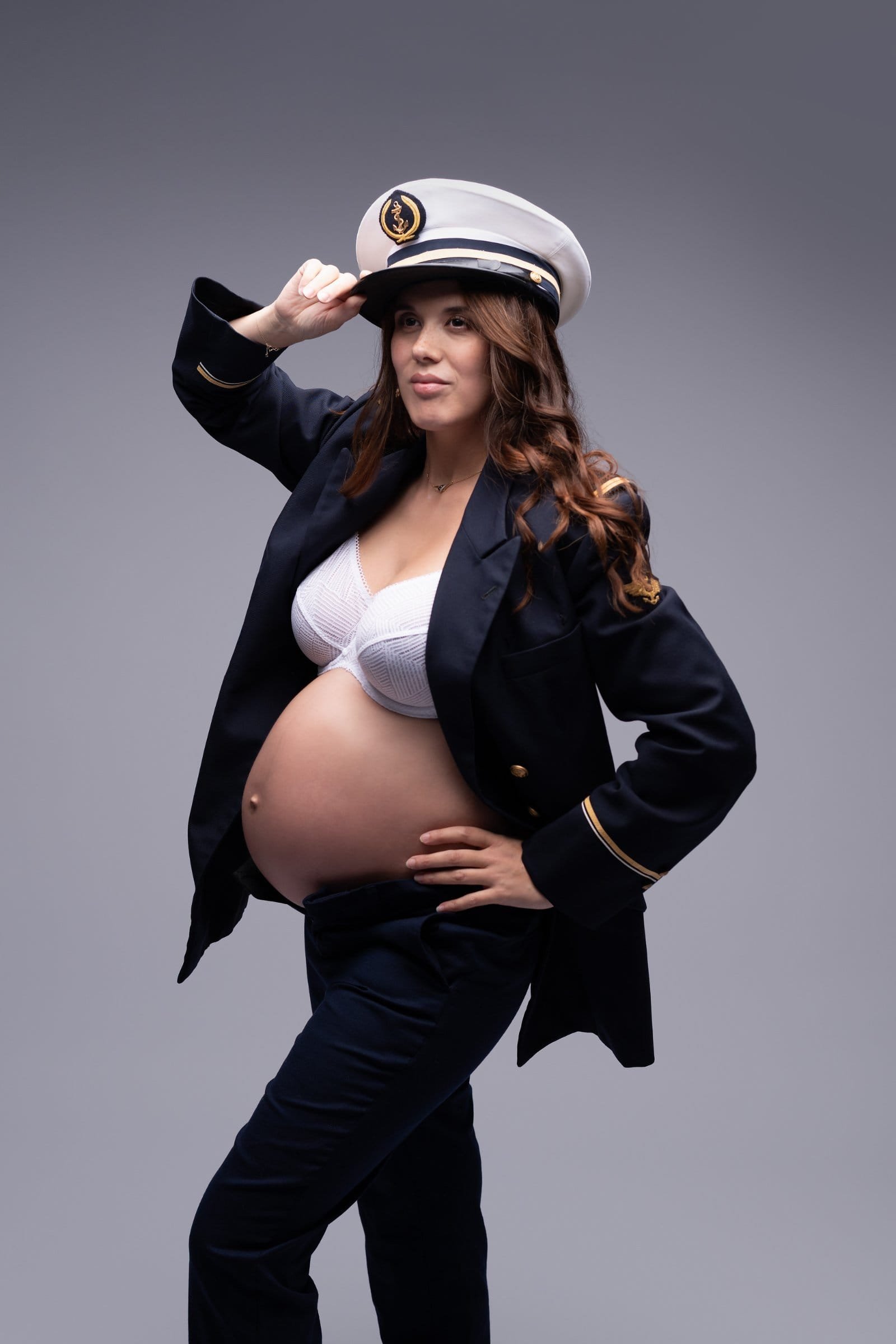 Portrait grossesse de femme seule en uniforme de la marine avec ventre arrondi apparent, par AEL Photos en studio au Faou, Bretagne